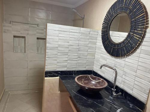 a bathroom with a sink and a mirror at Riad Eglantine in Touggana