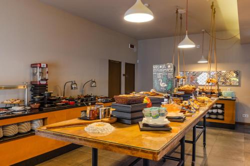 una mesa larga con comida en la cocina en Pestana Alvor South Beach Premium Suite Hotel, en Alvor