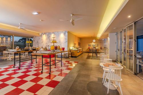 Un restaurante con suelo de cuadros y mesas y sillas. en Pestana Alvor South Beach Premium Suite Hotel, en Alvor