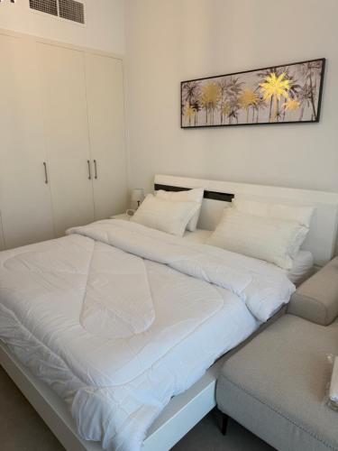 a bedroom with two beds and a chair at Beautiful studio at aljada community in Sharjah