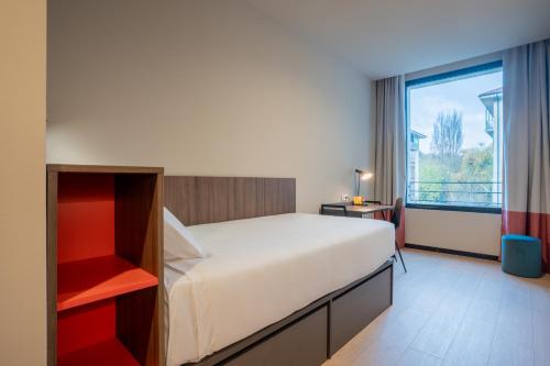 Un dormitorio con una cama grande y una ventana grande. en Lemonade Stays Santiago de Compostela, en Santiago de Compostela