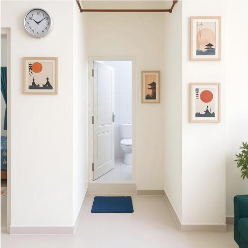 a hallway with a toilet and a clock on the wall at Casa61 Homestay in Bengaluru