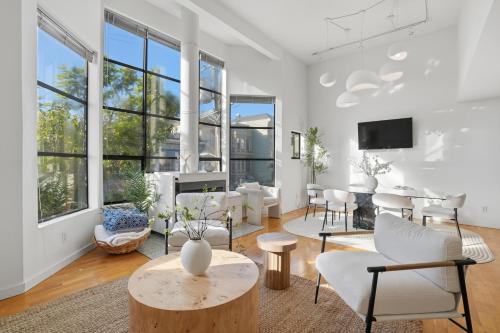 a living room with white furniture and windows at Bright Spacious & Comfortable Hayes Valley Condo in San Francisco