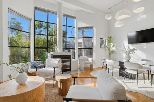 a living room with white furniture and windows at Bright Spacious & Comfortable Hayes Valley Condo in San Francisco