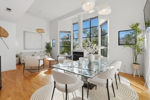 a dining room with a glass table and white chairs at Bright Spacious & Comfortable Hayes Valley Condo in San Francisco