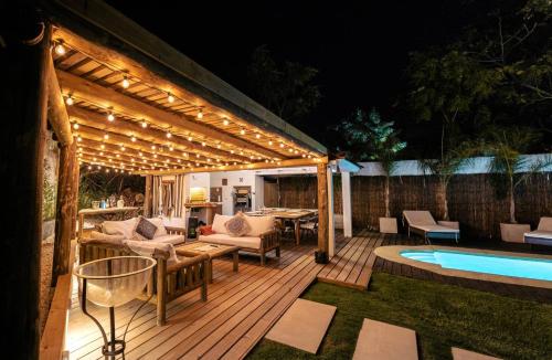 un pergolato con luci su un ponte accanto a una piscina di Villa Kunterbunt Punta del Este a Punta del Este