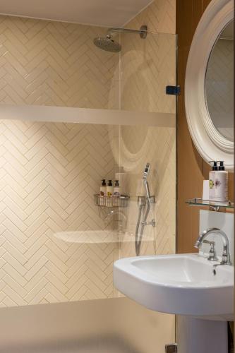 a bathroom with a sink and a glass shower at The Alma Hotel in London