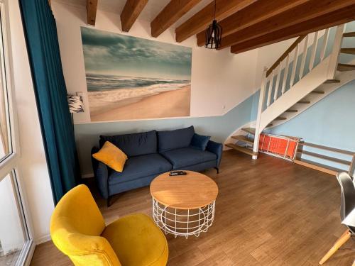 a living room with a blue couch and a table at KORALIA Domki StandardPlus JACUZZI na wyłączność, BASEN in Sarbinowo