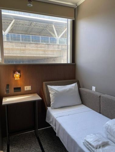 a small room with a bed and a window at Hotel Aero Sleep Campinas in Campinas