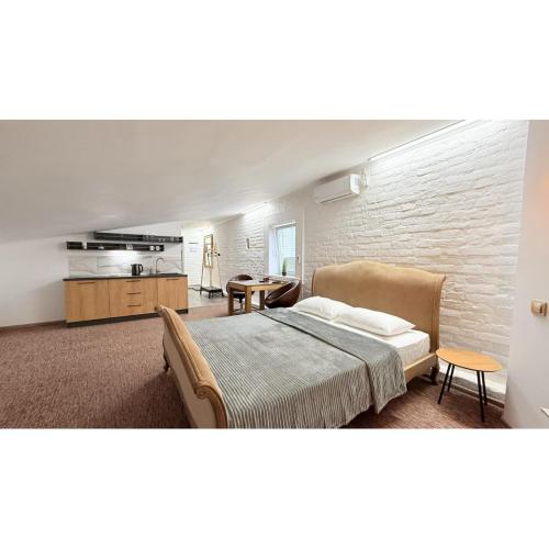 a bedroom with a bed and a table and a kitchen at Sumska Apartment Lux in Kharkiv