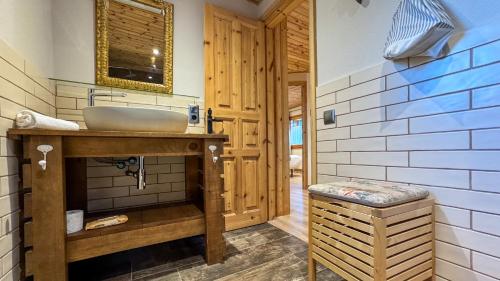 ein Badezimmer mit Waschbecken und Holztür in der Unterkunft Masía Cal Kenyon in Bor