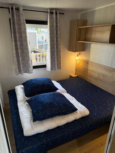 a bed with two pillows on it in a room at Chalet Meerhuus Lauwersoog in Lauwersoog