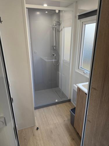 a bathroom with a shower with a glass door at Chalet Meerhuus Lauwersoog in Lauwersoog