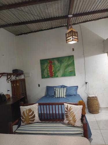 una camera da letto con un letto e un divano in una stanza di Raízes kit net a Itacaré