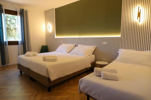 una camera d'albergo con due letti e una grande finestra di Hotel Al Posta a Casarsa della Delizia