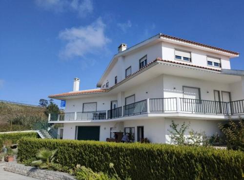 a white house with a balcony and bushes at Vergikosk House - villa 4 quartos com piscina privada in Bombarral
