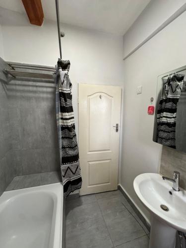 a bathroom with a white tub and a sink at The Vantage in Lusaka