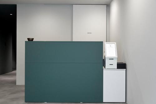 a blue wall with a machine and a microwave at Morf Stay in Seoul