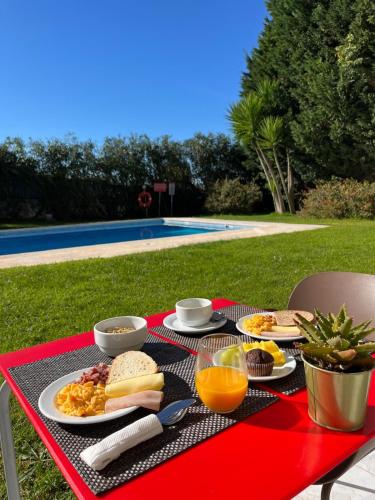 a picnic table with breakfast foods and orange juice on it at HILLTOP OASIS Lisboa Oeiras in Oeiras