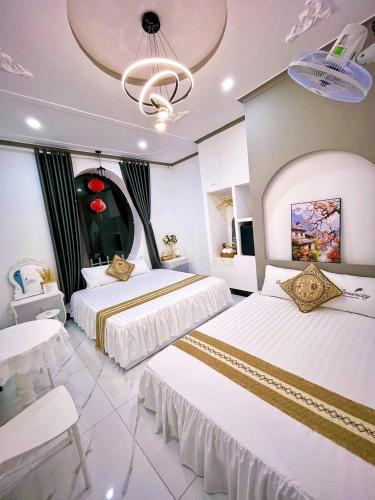 a hotel room with two beds and a chandelier at Hoàng Nga 1 Apartment in Phan Thiet