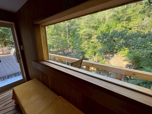 a window in a room with a view of a forest at 精神と時の宿 in Nose