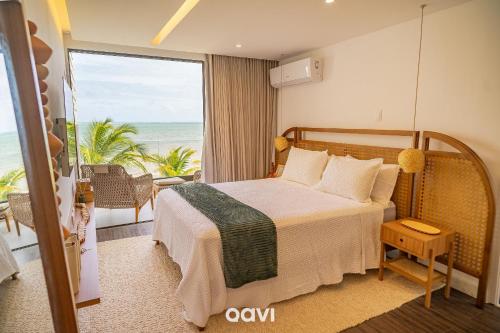 Barra do CamaragibeにあるCasa Duplex à Beira-mar OKA Milagres by Qaviのベッドがあり海が見える寝室
