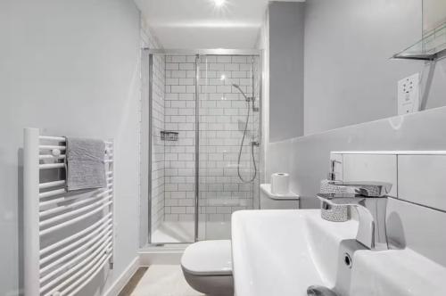 a white bathroom with a toilet and a shower at Birmingham City Center View in Birmingham