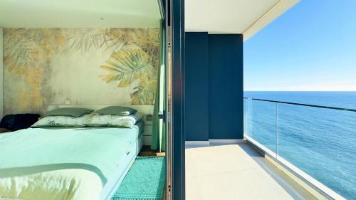 una camera da letto con un letto e vista sull'oceano di Sea Front a Câmara de Lobos