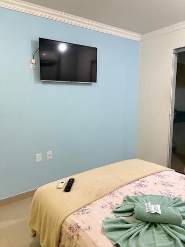 a bedroom with a bed with a flat screen tv on the wall at Quarto privado próximo ao centro 10 in Manaus