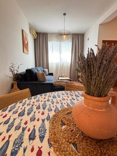 a living room with a vase on a table at Flora Apartment - near the sea in Bar, Susanj
