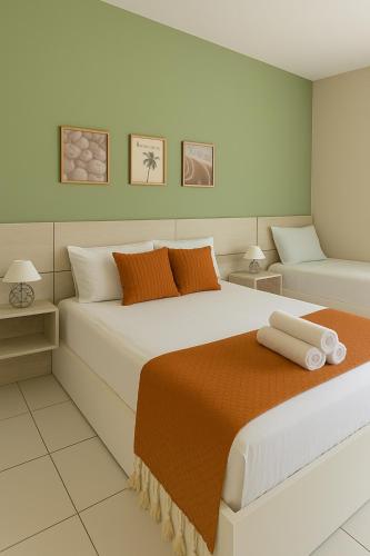 a bedroom with a large bed with orange and white pillows at Residencial New Stilo-Falésia in Canoa Quebrada