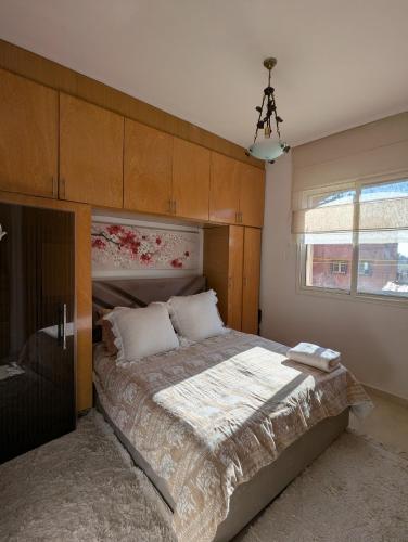 Appartement à 5 min de la plage, piscine et parking privé في بن سليمان: غرفة نوم بسرير كبير مع لوح رأس خشبي