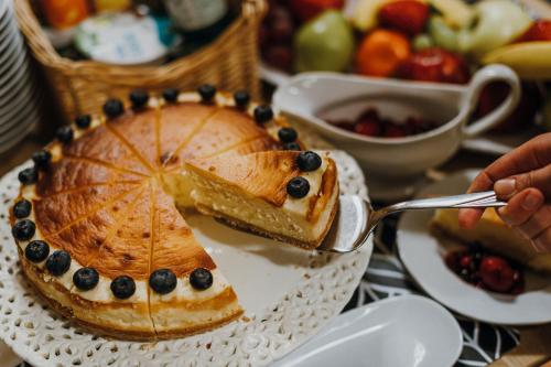a person is eating a piece of cake on a plate at Hotel Piano in Szeged