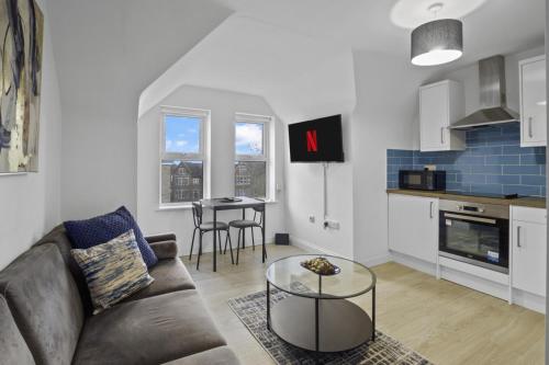 a living room with a couch and a table at Modern Apartment I Self Check-in I Wi-Fi I Free Private Parking I Sleeps 3 in Bedford