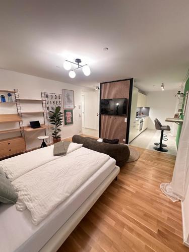 Modernes City Apartment inkl Garage und Balkon في لينز: غرفة نوم بها سرير كبير وغرفة معيشة