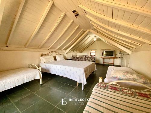 um quarto com 2 camas num quarto com tectos em Chácara c/ Piscina, Churrasqueira com vista linda em Poços de Caldas