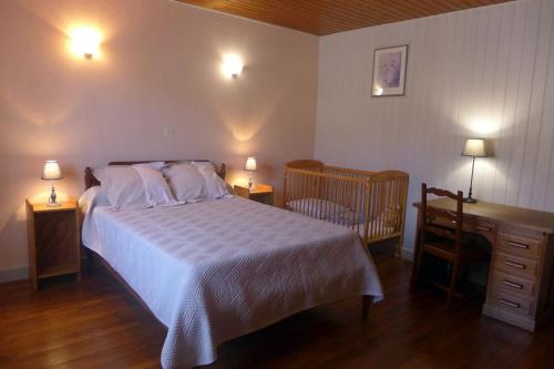 ein Schlafzimmer mit einem Bett, einem Schreibtisch und einem Kinderbett in der Unterkunft Les pierres blanches in Aubepierre-sur-Aube