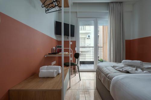 ein Schlafzimmer mit einem Bett und einem Schreibtisch mit Stuhl in der Unterkunft City Vibe Standard in Thessaloniki