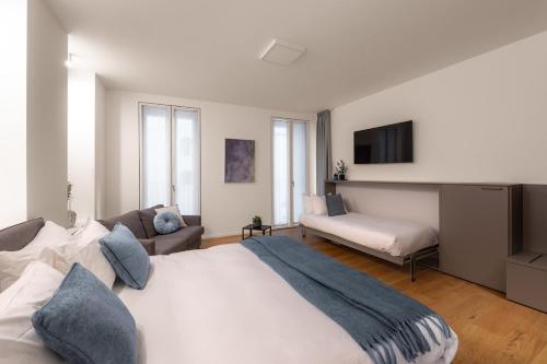 a bedroom with a large white bed and a couch at The Golden Studio by Aura Luxury Collection in Como