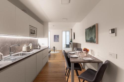 a kitchen with a table with chairs and a sink at The Golden Studio by Aura Luxury Collection in Como