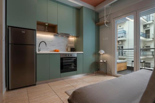 eine Küche mit grünen Wänden und einem Kühlschrank in der Unterkunft City Vibe Standard in Thessaloniki