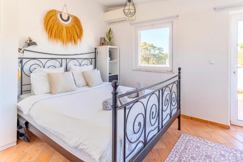 a bedroom with a black bed with white sheets at Casa Oceano-Mar a vista in Raposeira
