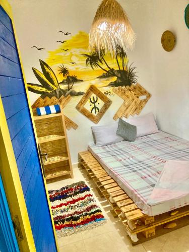 a bedroom with a bed and a surfboard on the wall at Boilers Surf House in Tamri