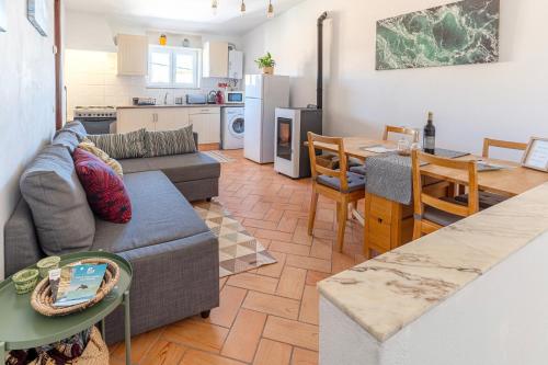 a living room and kitchen with a couch and a table at Casa Oceano-Mar a vista in Raposeira