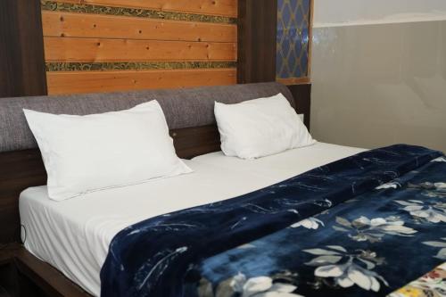 a bed with two pillows and a blanket on it at SRT Rajmahal Famliy Hotel Luxa RoadVARANSHI in Varanasi
