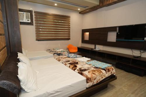 a bedroom with a large bed and a flat screen tv at SRT Rajmahal Famliy Hotel Luxa RoadVARANSHI in Varanasi