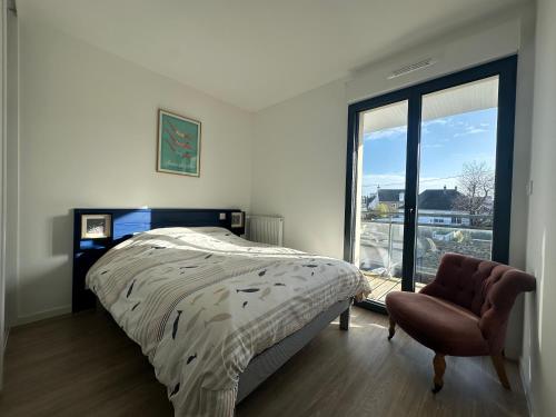 a bedroom with a bed and a chair and a window at Les cabines de Granville in Granville