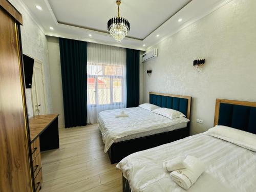 a hotel room with two beds and a chandelier at Soro Hotel in Dushanbe