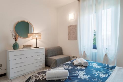 a bedroom with a bed and a dresser and a mirror at I Lavatoi Iseo - apartment in Iseo