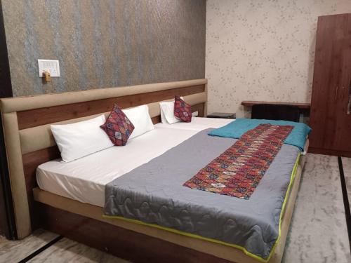 a bedroom with a bed with white sheets and pillows at Soni's Mansion-100m from Khajuraho Temples in Khajurāho